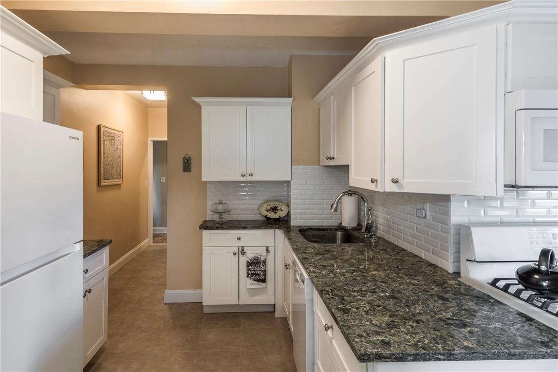 a kitchen with stainless steel appliances granite countertop a stove a refrigerator and white cabinets