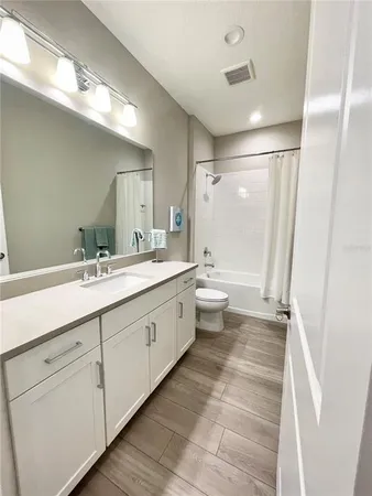 a bathroom with a double vanity sink a toilet and a mirror
