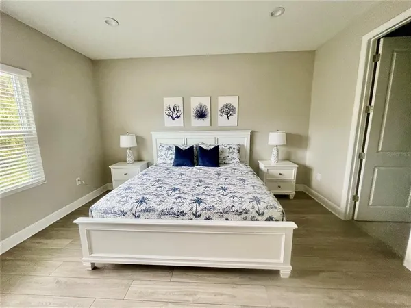 a living room with stainless steel appliances furniture a rug and a window