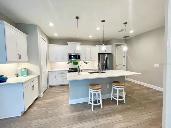 a kitchen with a table chairs sink and cabinets