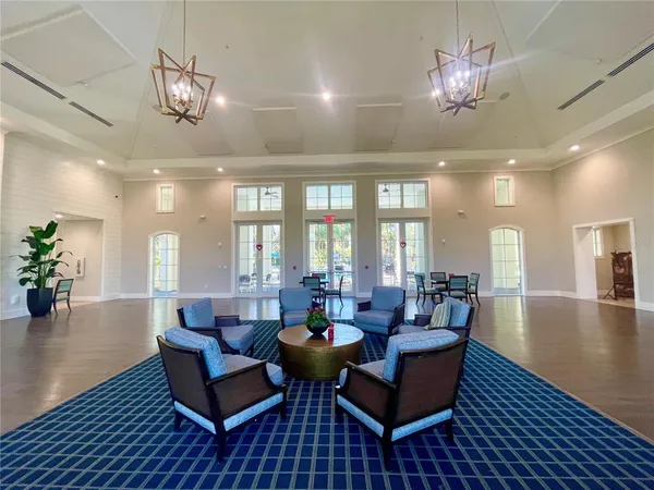 a living room with furniture a chandelier and a dining table