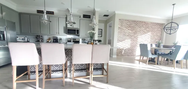a dining room with wooden floor a chandelier a glass table and chairs