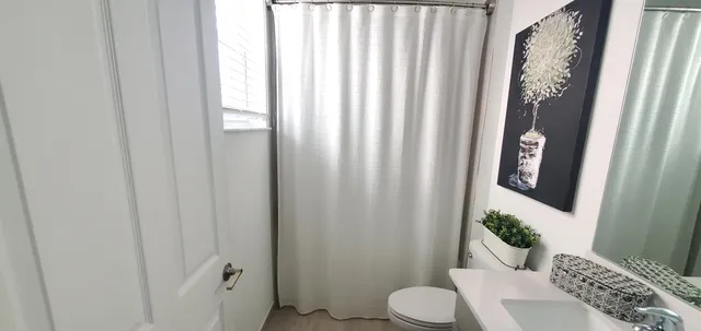 a bathroom with a toilet and shower curtain