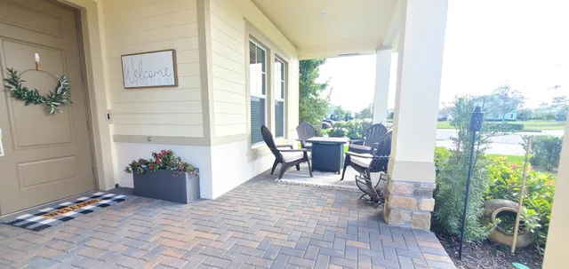 a view of a porch with chairs and potted plants