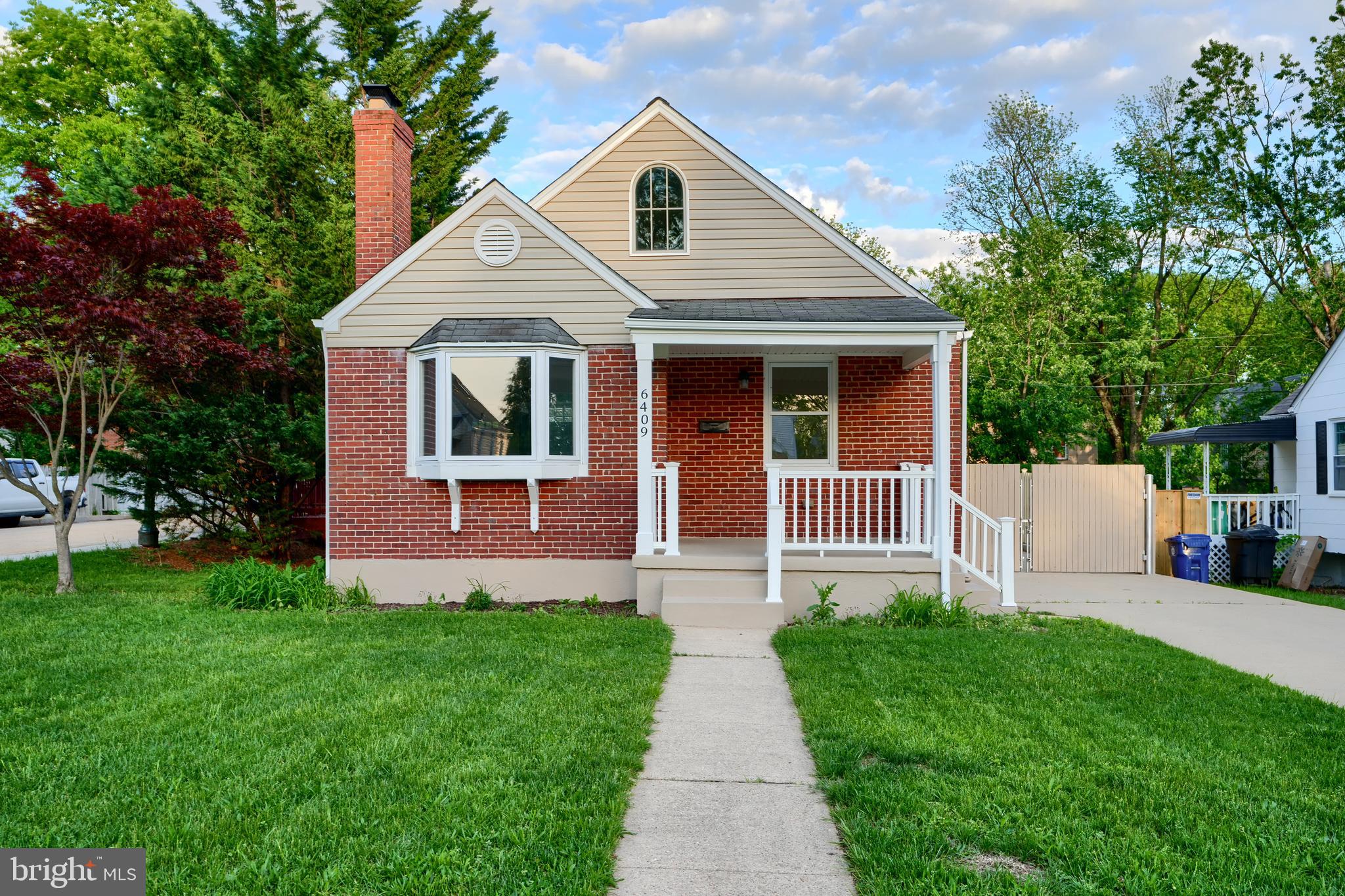 a front view of a house with a yard and trees