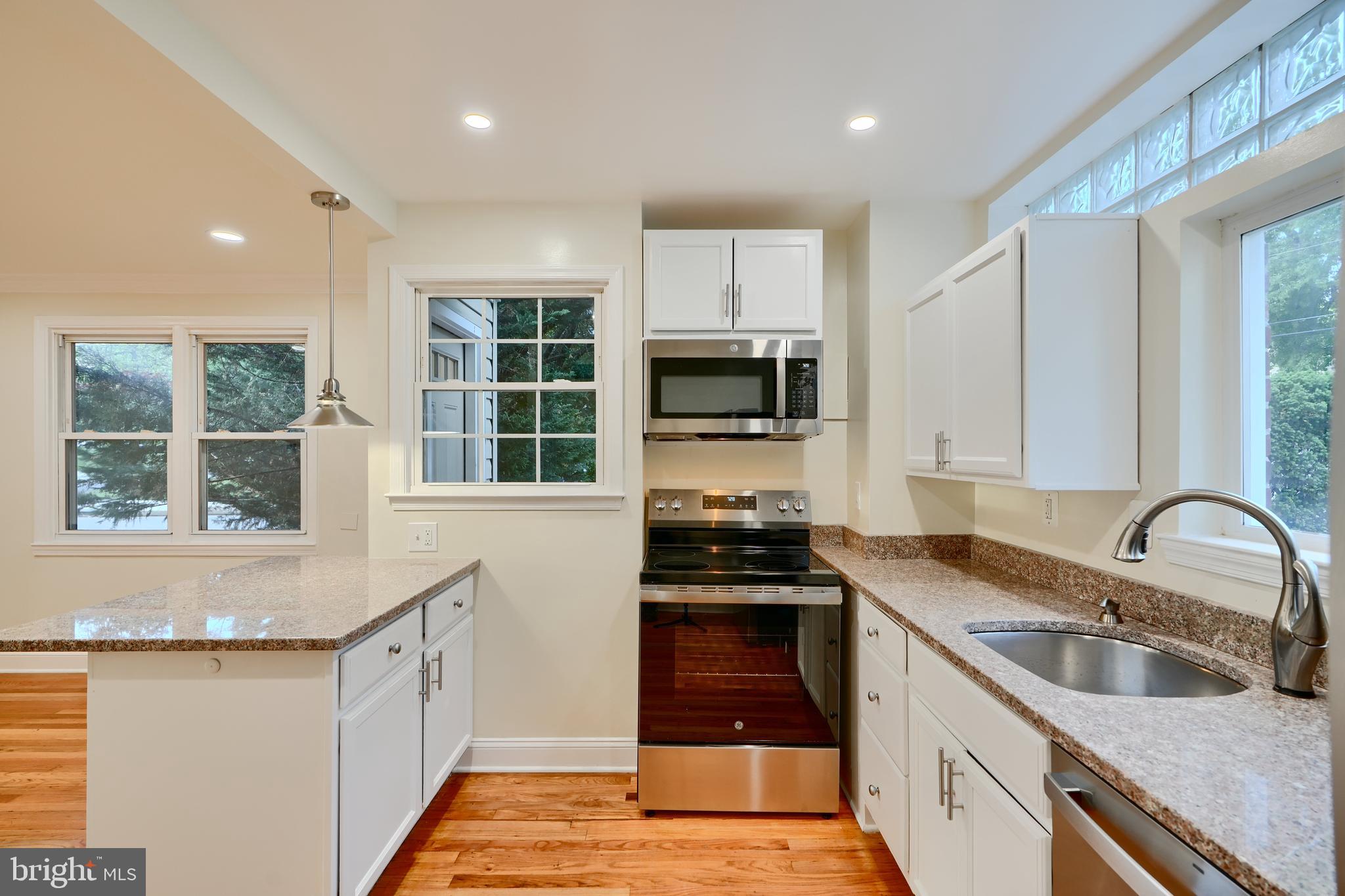 6409 Eastern Parkway Baltimore, MD 21214 - Photo 13 of 56 a kitchen with granite countertop a stove sink and microwave