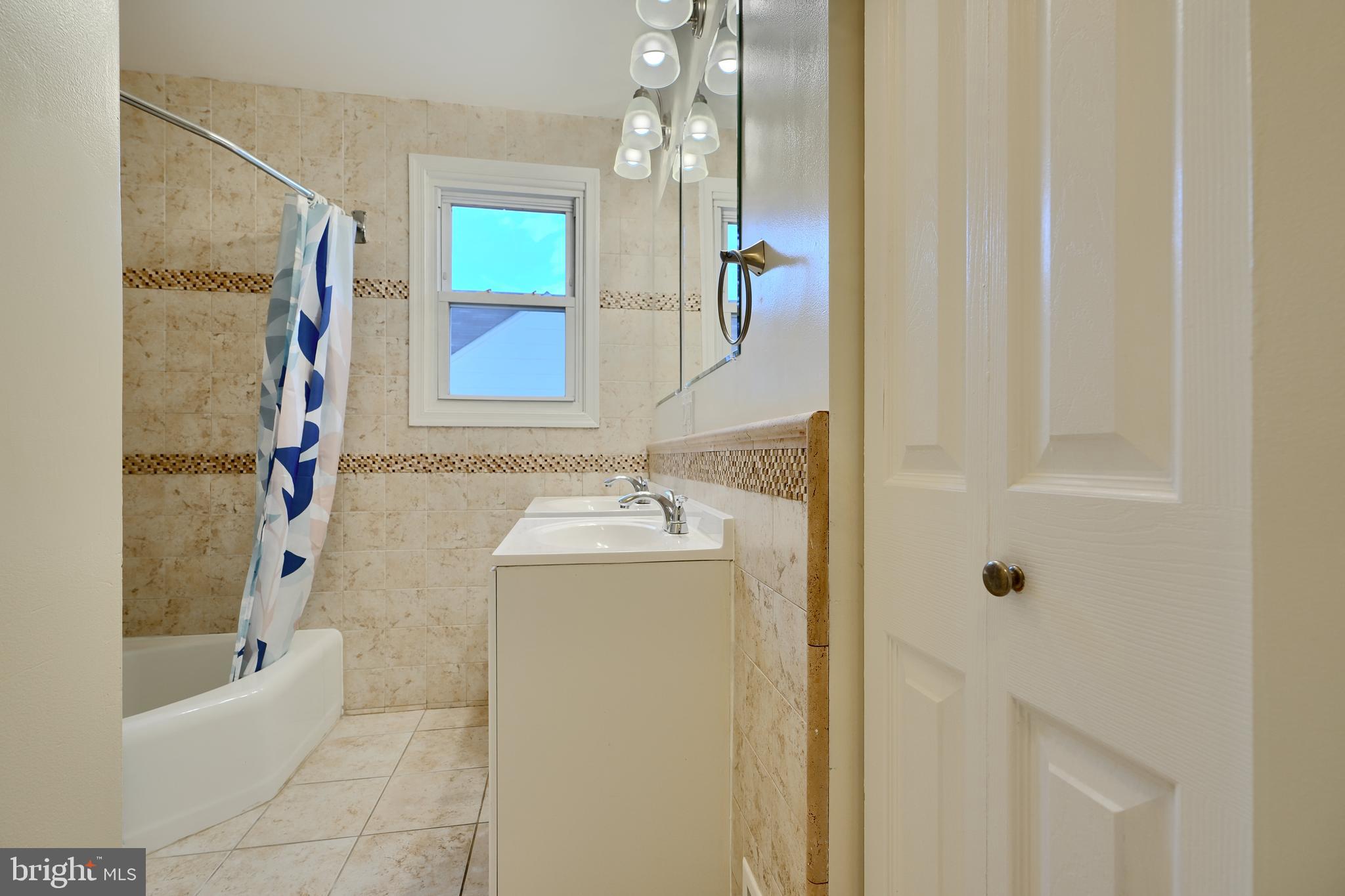 6409 Eastern Parkway Baltimore, MD 21214 - Photo 20 of 56 a bathroom with a granite countertop sink a mirror and shower