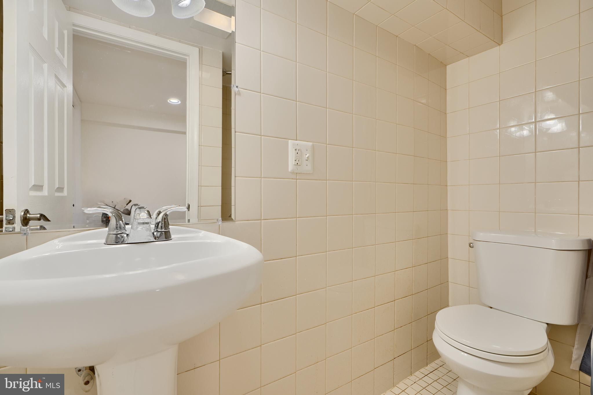 6409 Eastern Parkway Baltimore, MD 21214 - Photo 40 of 56 a bathroom with a sink a toilet and mirror