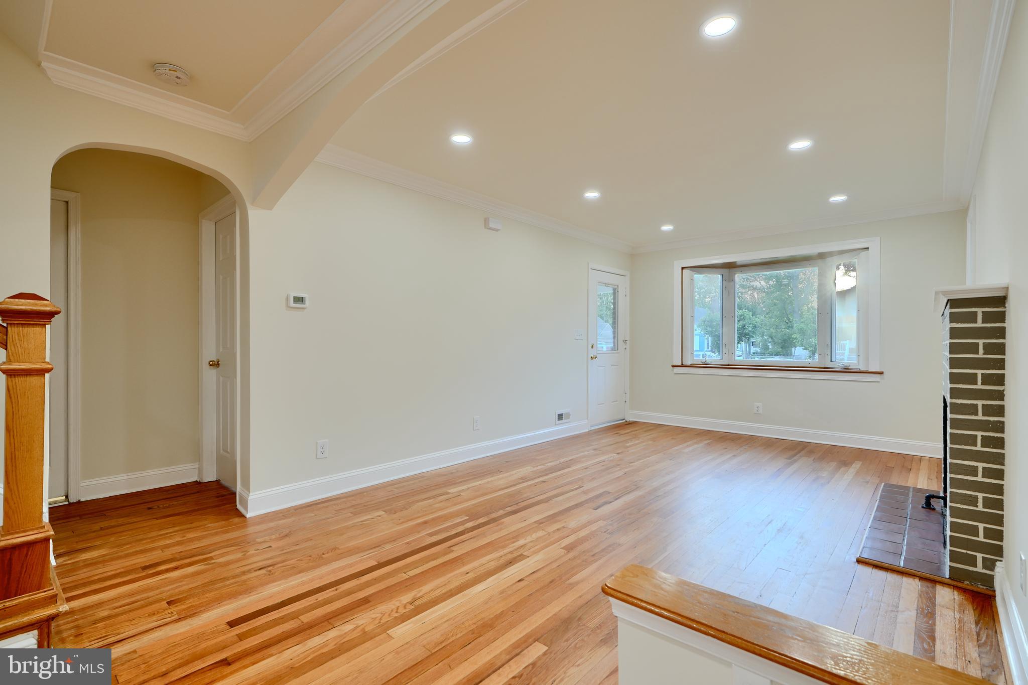 6409 Eastern Parkway Baltimore, MD 21214 - Photo 9 of 56 a view of an empty room with wooden floor and a window