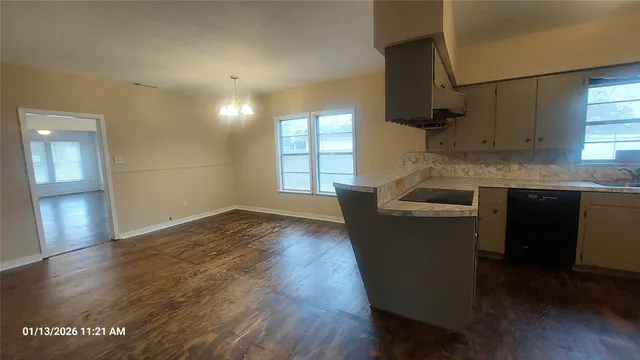 a kitchen with granite countertop a sink a stove and cabinets