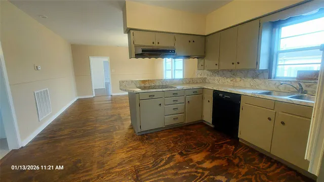 a kitchen with a sink cabinets and window