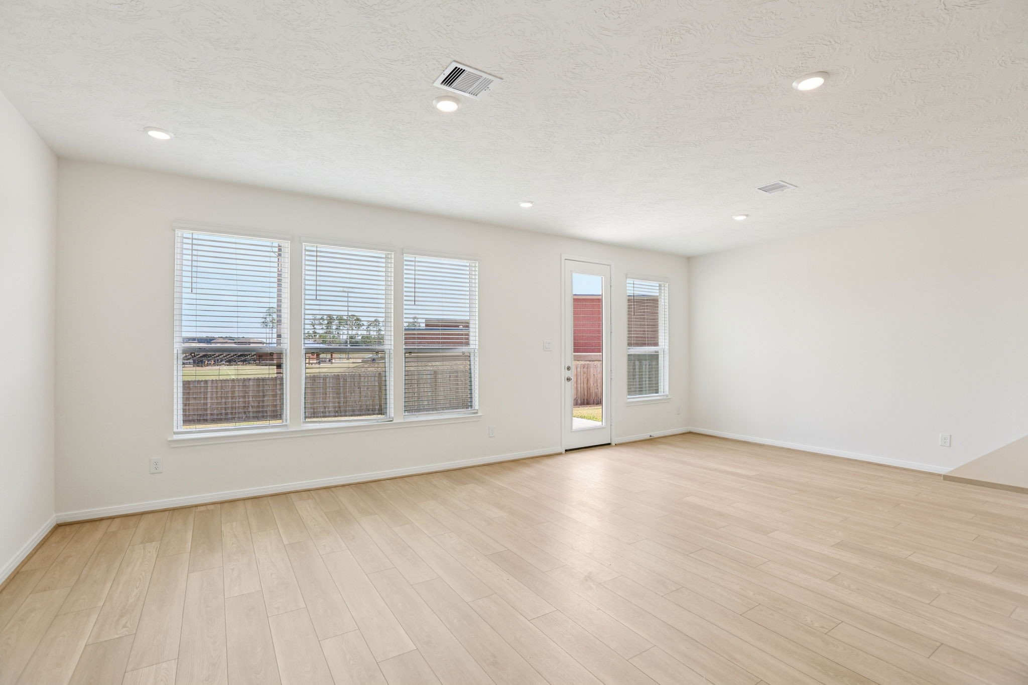 3530 Dryer Park Drive Spring, TX 77373 - Photo 15 of 48 Flooded with natural light from large windows and a patio door, the Great Room feels bright and airy. Recessed lighting adds to the welcoming atmosphere, perfect for gathering with family and guests.
