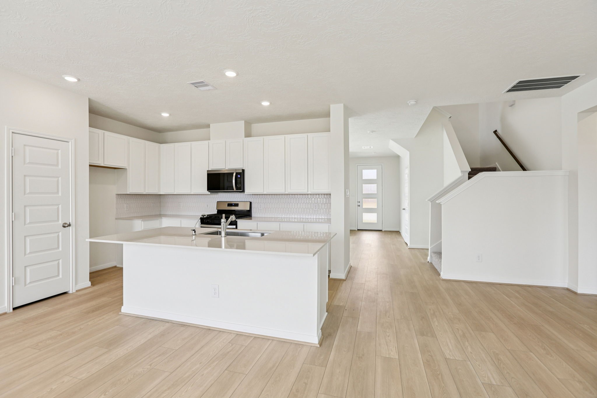 3530 Dryer Park Drive Spring, TX 77373 - Photo 19 of 48 The kitchen features high ceilings, stained wood cabinets, Silestone countertops, SS appliances including microwave, modern tile backsplash, recessed lighting, huge kitchen island extended for a breakfast bar, and a pantry all overlooking your huge family room.
