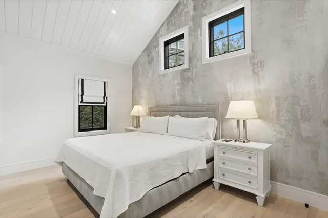 a bedroom with a bed and a lamp on the dresser