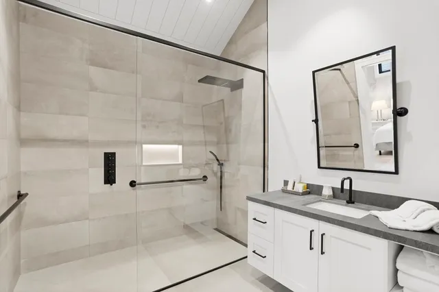 a bathroom with a granite countertop sink mirror and shower