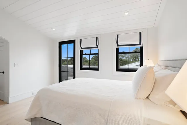 a large bed sitting in a bedroom next to a window