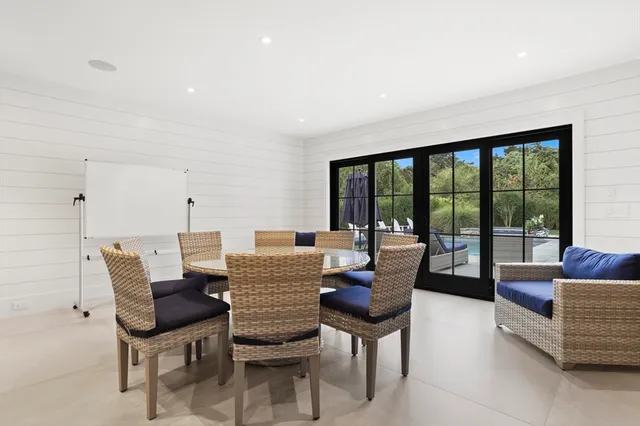 a dining room with furniture and a floor to ceiling window