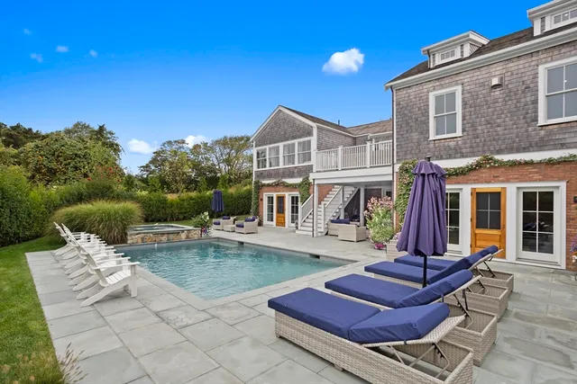 a view of a house with pool and chairs