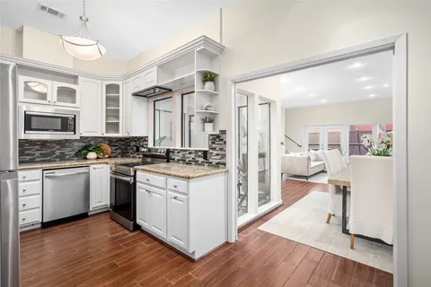 a kitchen with stainless steel appliances granite countertop hardwood floor sink stove and wooden floor