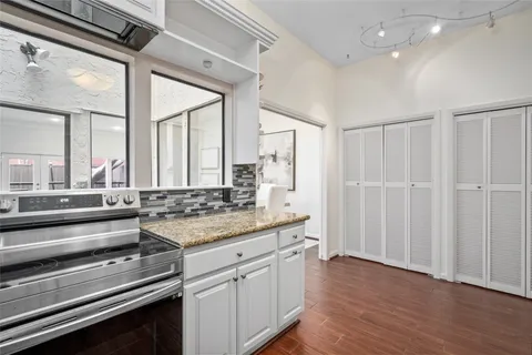 a kitchen with a stove and a wooden floor