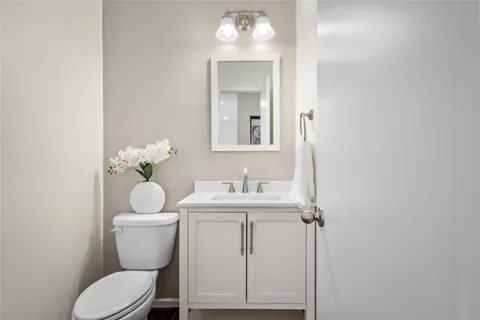 a bathroom with a toilet a sink and mirror