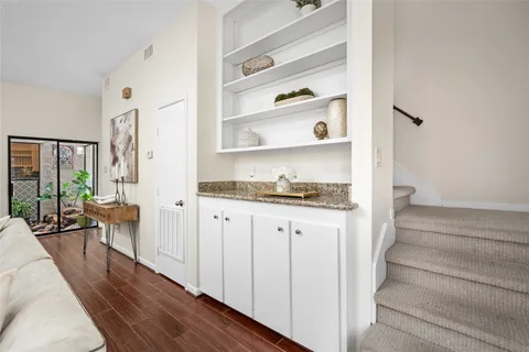 a hallway with white cabinets and wooden floor