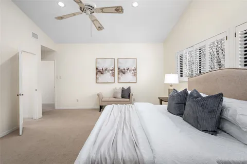 a spacious bedroom with a bed and painting on the wall