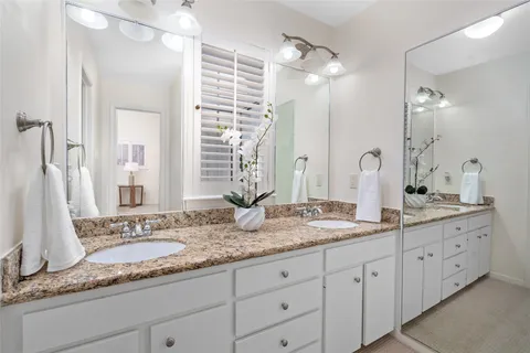 a bathroom with double sink and a mirror