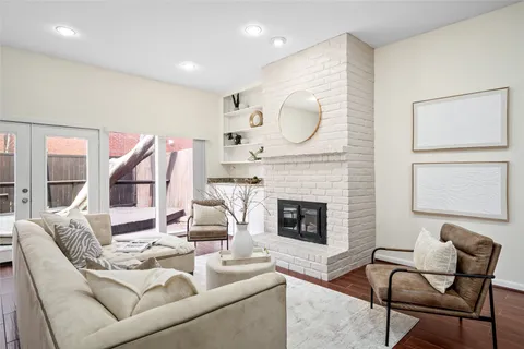 a living room with furniture a fireplace and a large window
