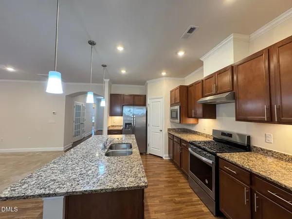 a large kitchen with stainless steel appliances kitchen island granite countertop a large counter top and stove