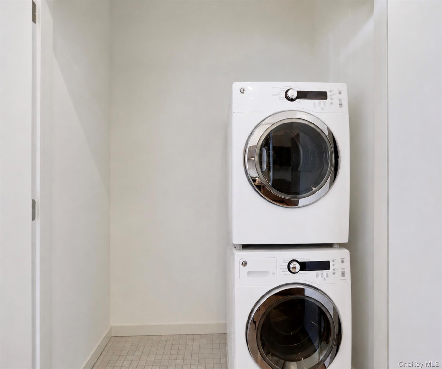 2 2nd Street, Unit 34 Rye, NY 10580 - Photo 8 of 8 In-unit laundry closet with tile floors, stacked washer and dryer, and storage space