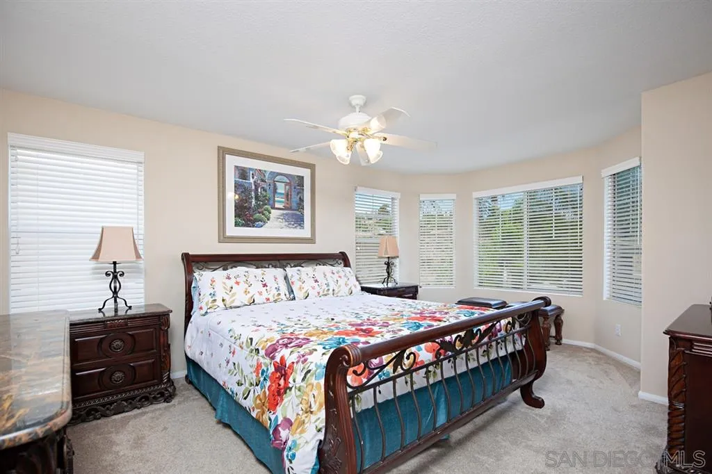 2170 Boulders Road Alpine, CA 91901 - Photo 15 of 24 a bedroom with a bed and a chandelier