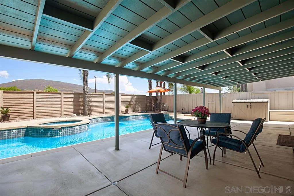 2170 Boulders Road Alpine, CA 91901 - Photo 23 of 24 a view of a patio with table and chairs and couches with wooden roof and stairs