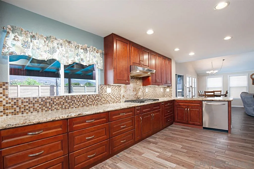 2170 Boulders Road Alpine, CA 91901 - Photo 5 of 24 a kitchen with stainless steel appliances granite countertop wooden cabinets and a large window