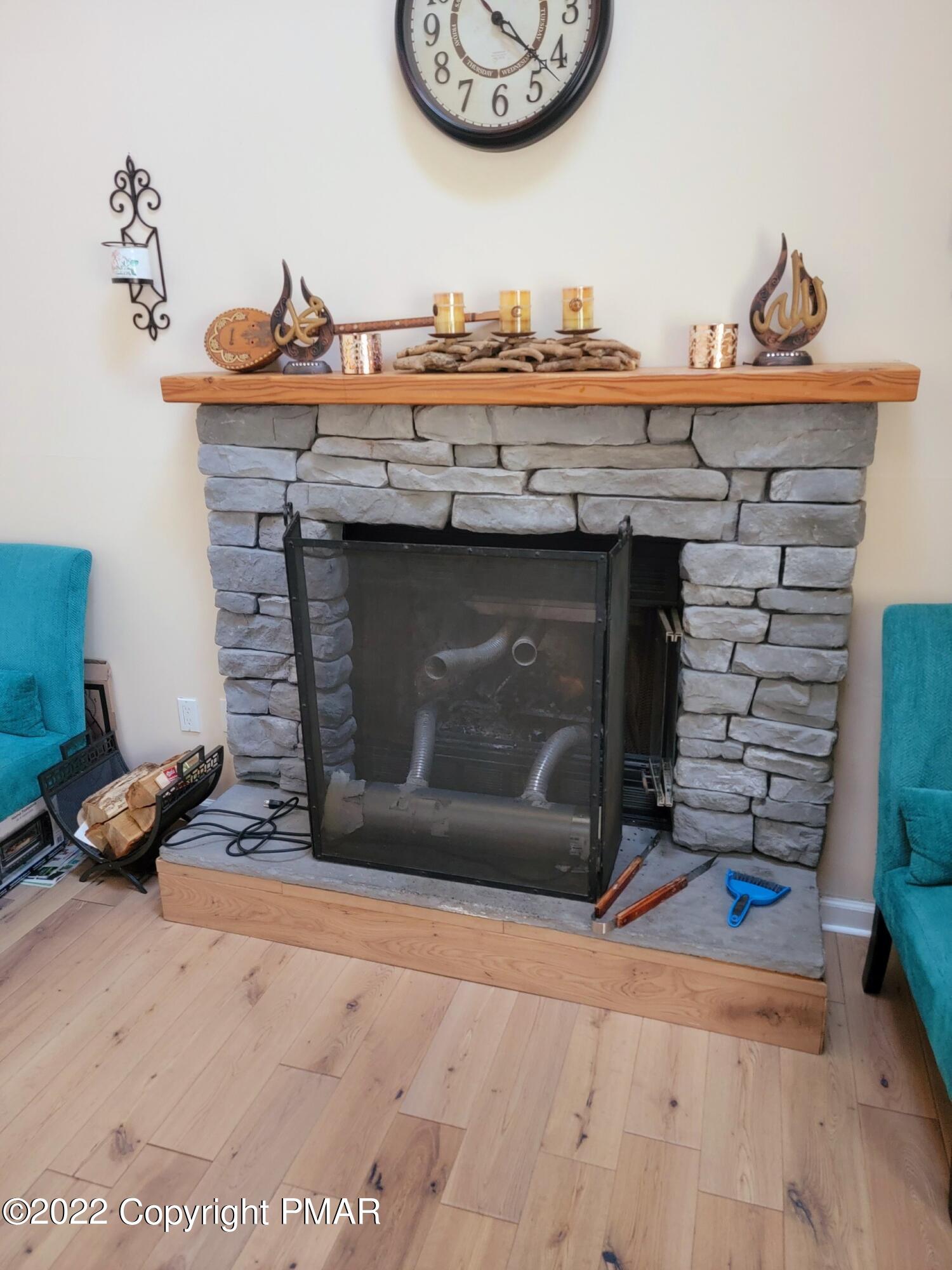 5665 Decker Road Bushkill, PA 18324 - Photo 14 of 32 a fireplace with a clock on top of it