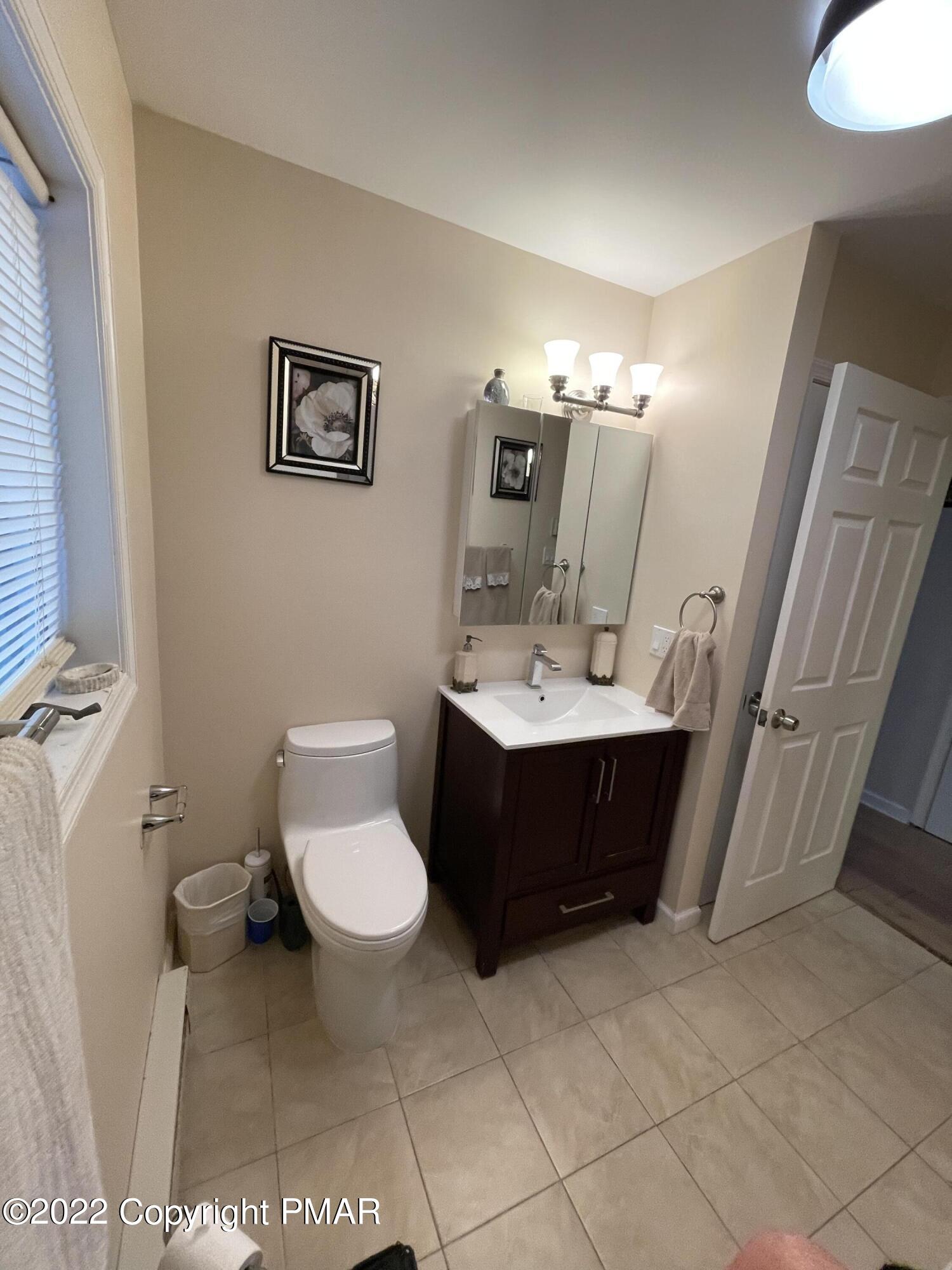 5665 Decker Road Bushkill, PA 18324 - Photo 16 of 32 a bathroom with a sink a toilet and mirror