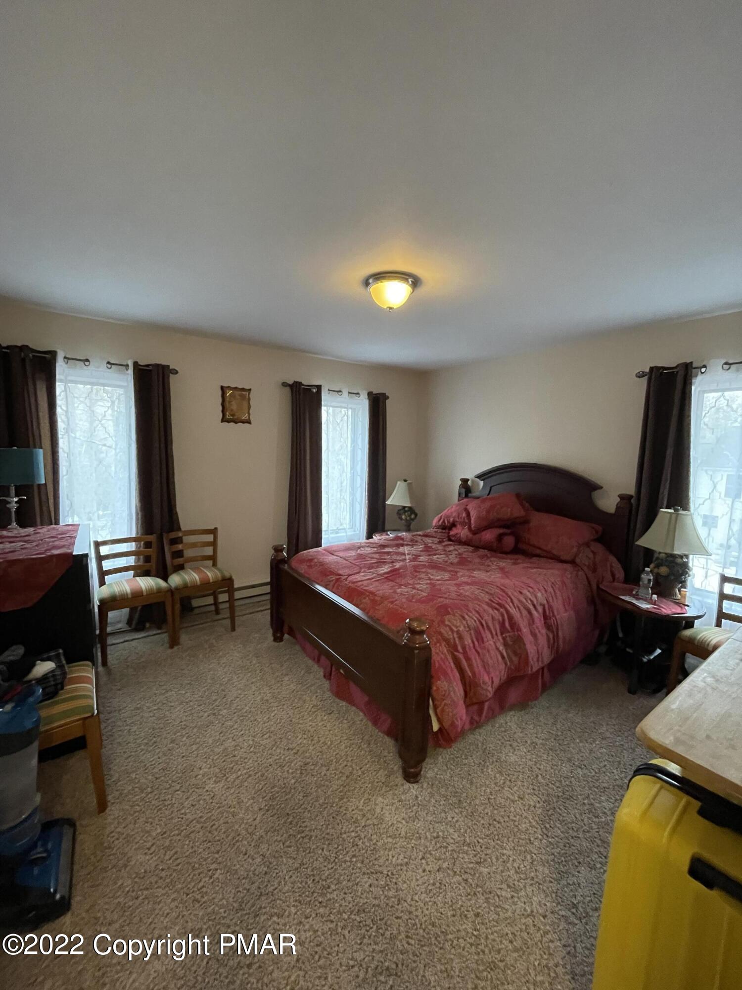 5665 Decker Road Bushkill, PA 18324 - Photo 17 of 32 a spacious bedroom with a bed and a couch