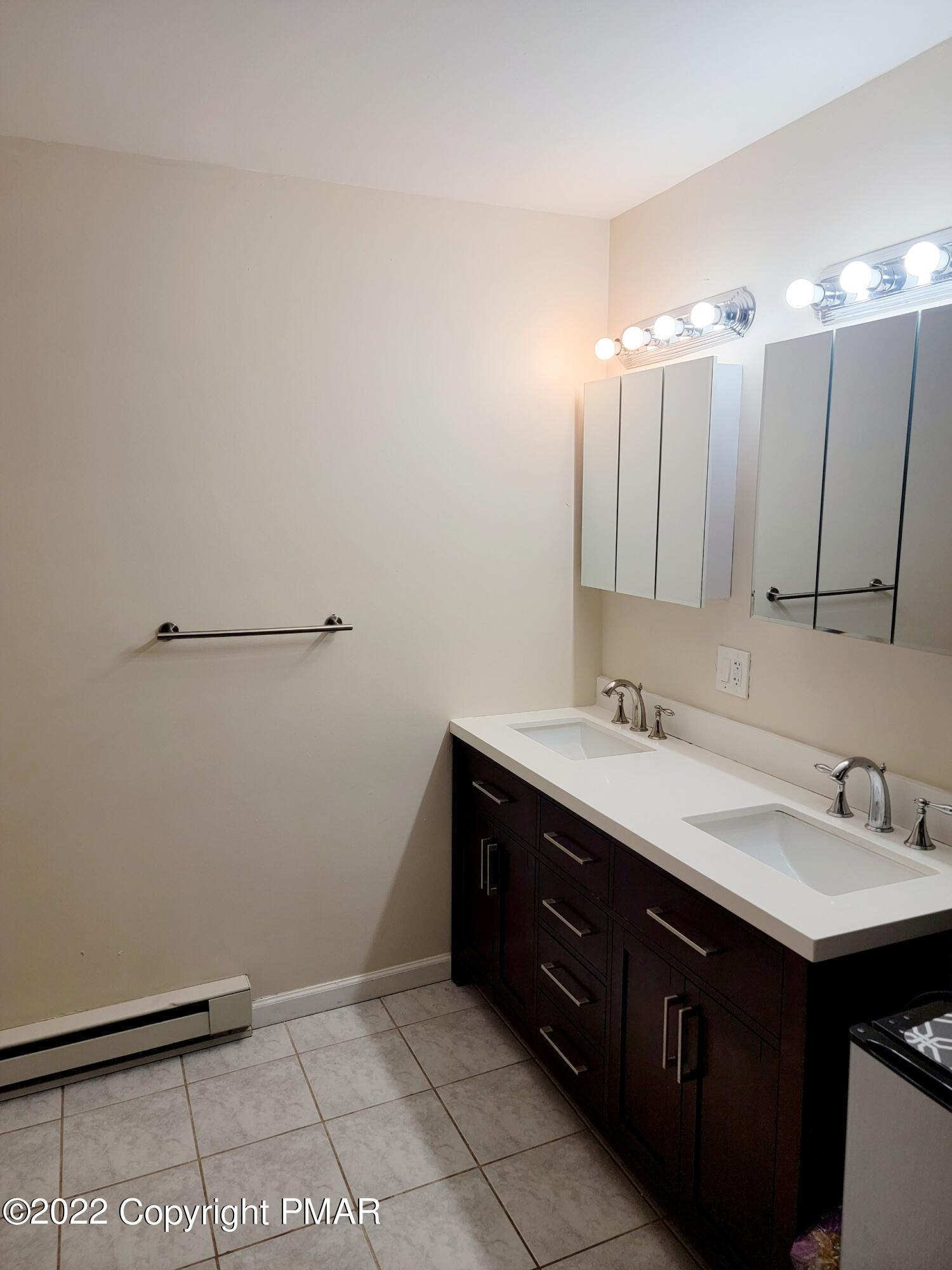 5665 Decker Road Bushkill, PA 18324 - Photo 23 of 32 a bathroom with a sink double vanity and a mirror