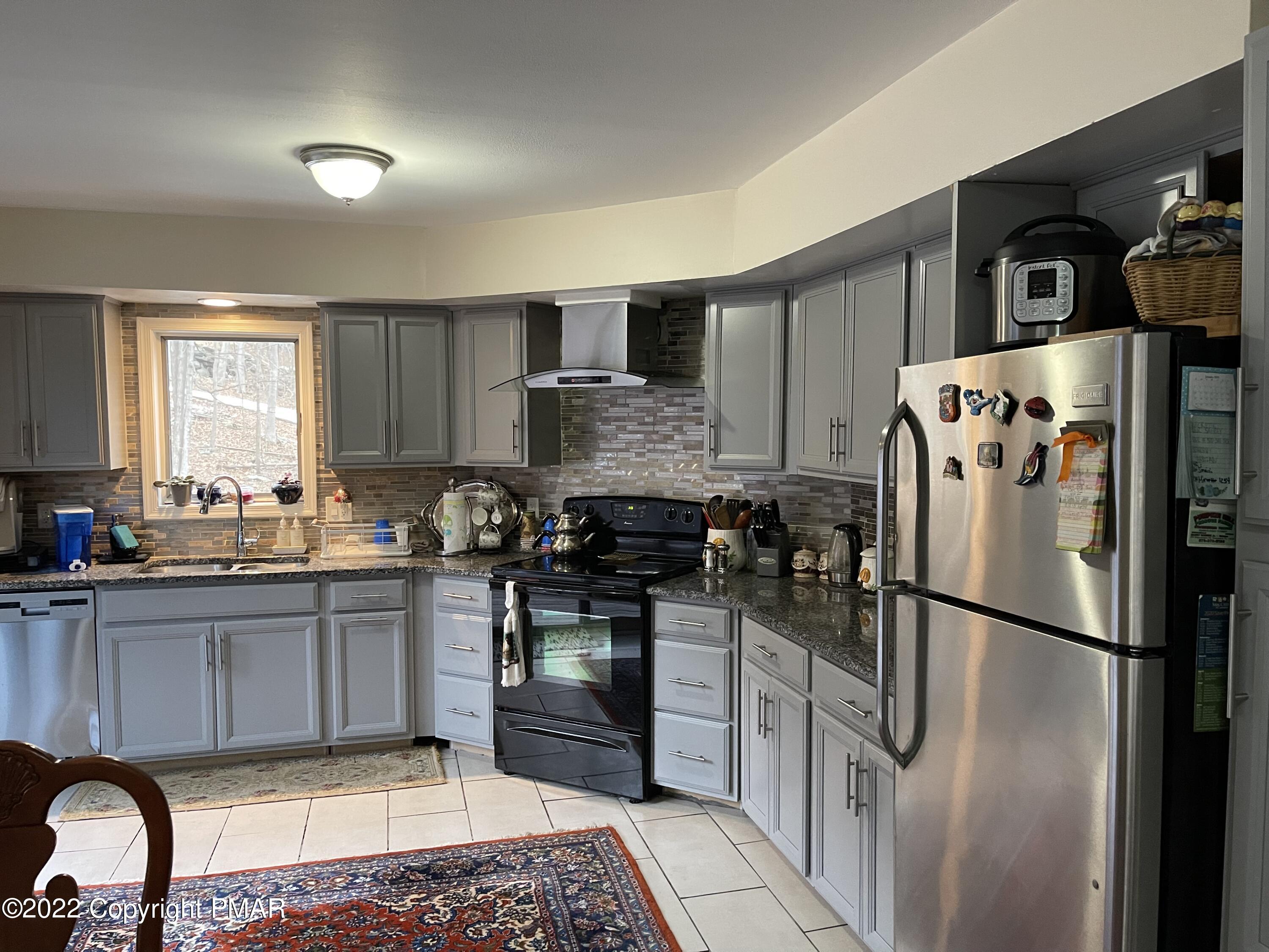 5665 Decker Road Bushkill, PA 18324 - Photo 7 of 32 a kitchen with stainless steel appliances granite countertop a refrigerator sink and stove