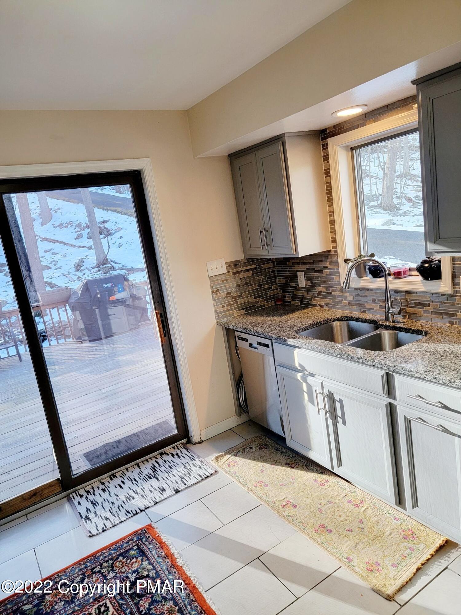 5665 Decker Road Bushkill, PA 18324 - Photo 9 of 32 a kitchen with stainless steel appliances granite countertop a stove a sink and a microwave