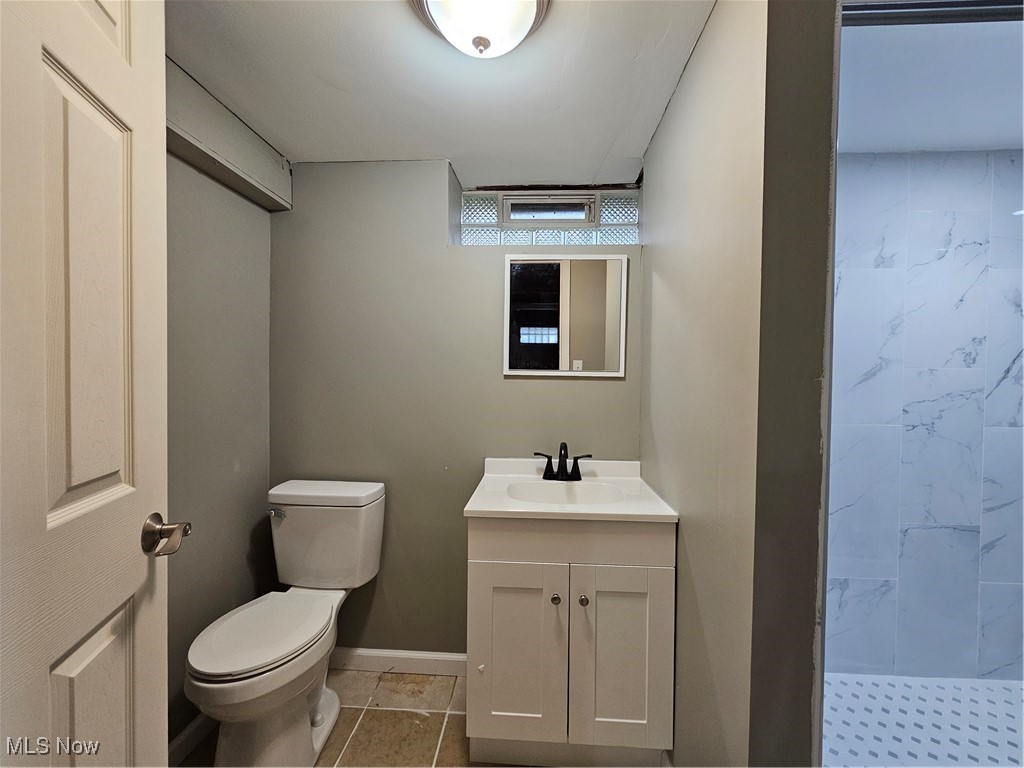 13514 Granger Road Cleveland, OH 44125 - Photo 17 of 23 Bathroom featuring tile patterned flooring, a shower, vanity, and toilet
