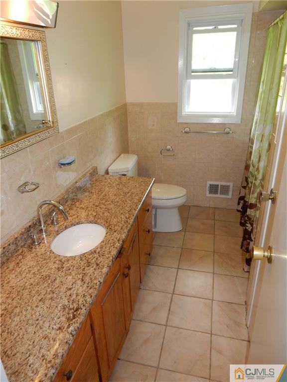 428 Morristown Road Old Bridge, NJ 07747 - Photo 15 of 25 a bathroom with a sink a toilet and mirror
