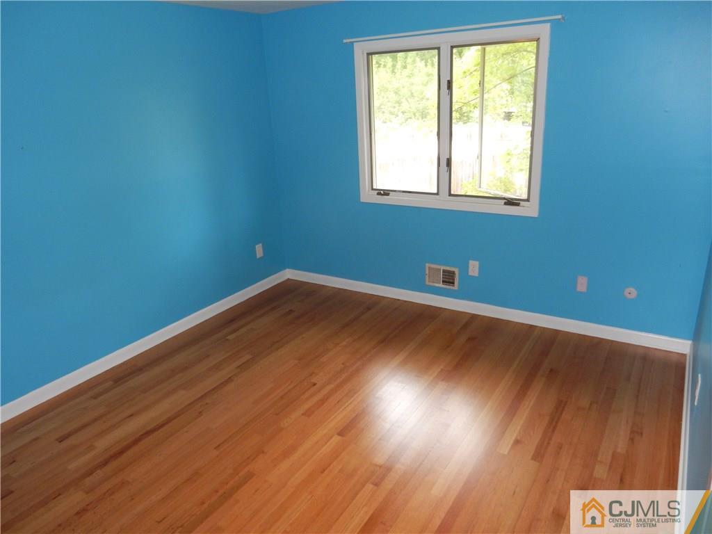 428 Morristown Road Old Bridge, NJ 07747 - Photo 16 of 25 an empty room with wooden floor and windows