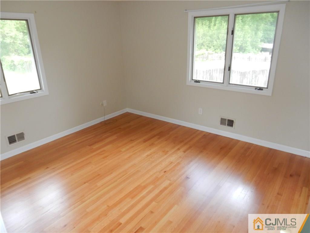 428 Morristown Road Old Bridge, NJ 07747 - Photo 17 of 25 an empty room with wooden floor and windows
