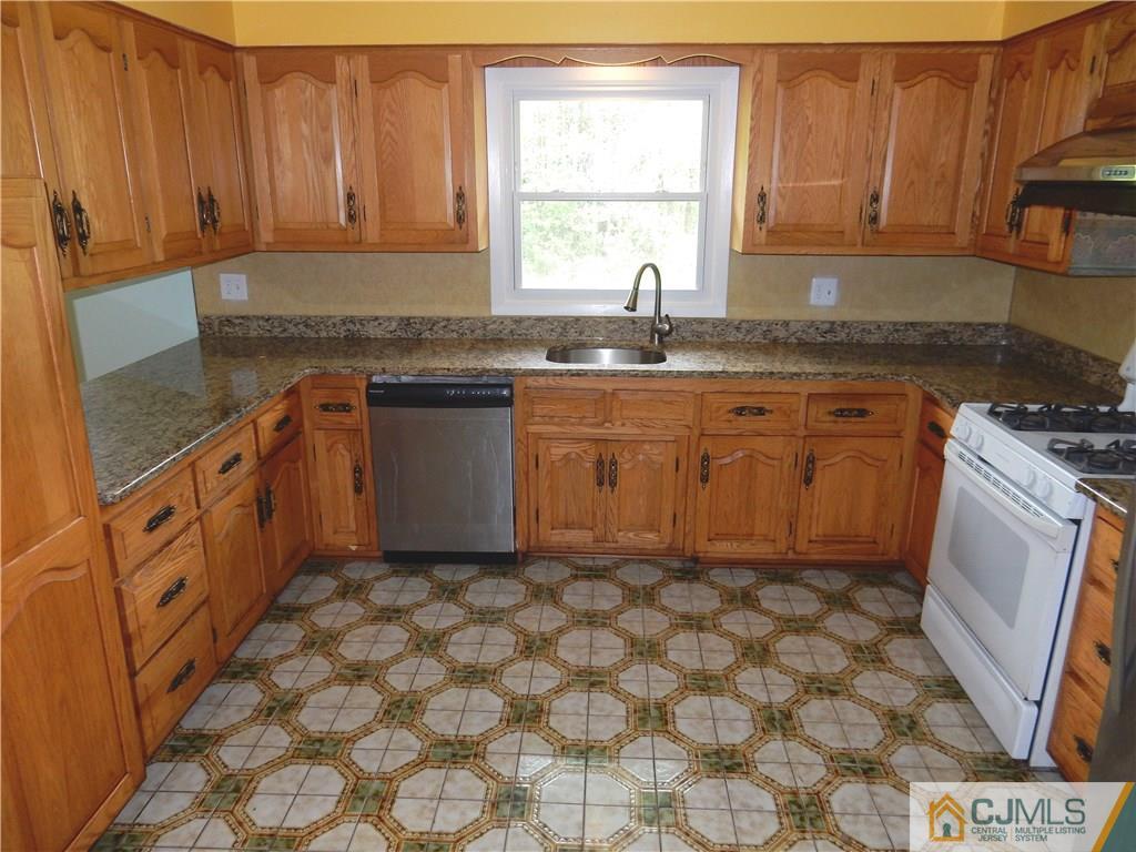 428 Morristown Road Old Bridge, NJ 07747 - Photo 7 of 25 a kitchen with stainless steel appliances granite countertop a sink stove and cabinets