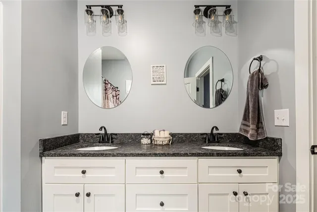 a bathroom with a granite countertop double vanity sinks and a mirror