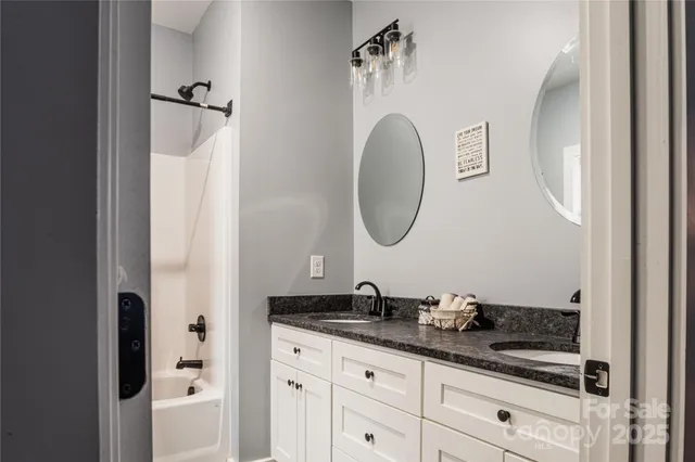 a bathroom with a granite countertop sink a mirror and a vanity