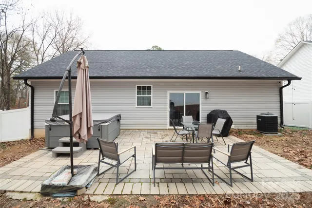 a view of a patio with table and chairs with wooden floor and fence