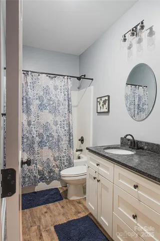 a bathroom with a granite countertop sink toilet a mirror and shower