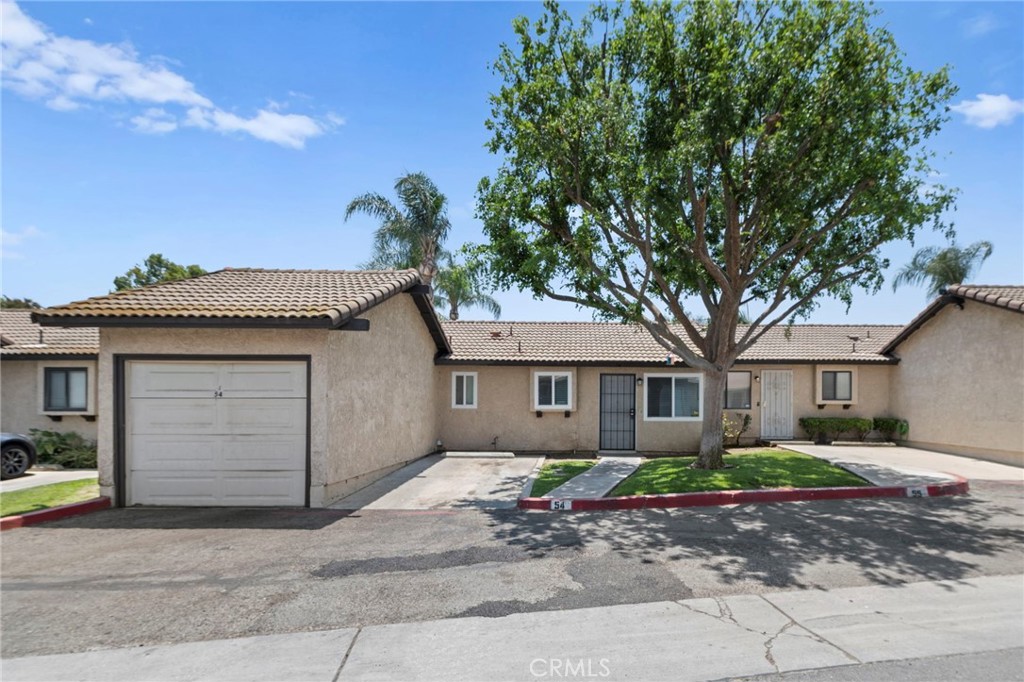 9505 Arlington Avenue, Unit 54 Riverside, CA 92503 - Photo 2 of 29 a front view of a house with a garden and trees